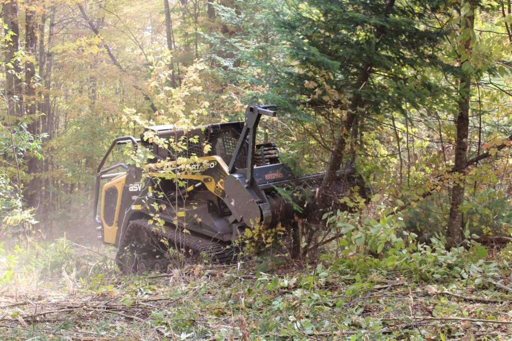 Forestry head skid steer at work